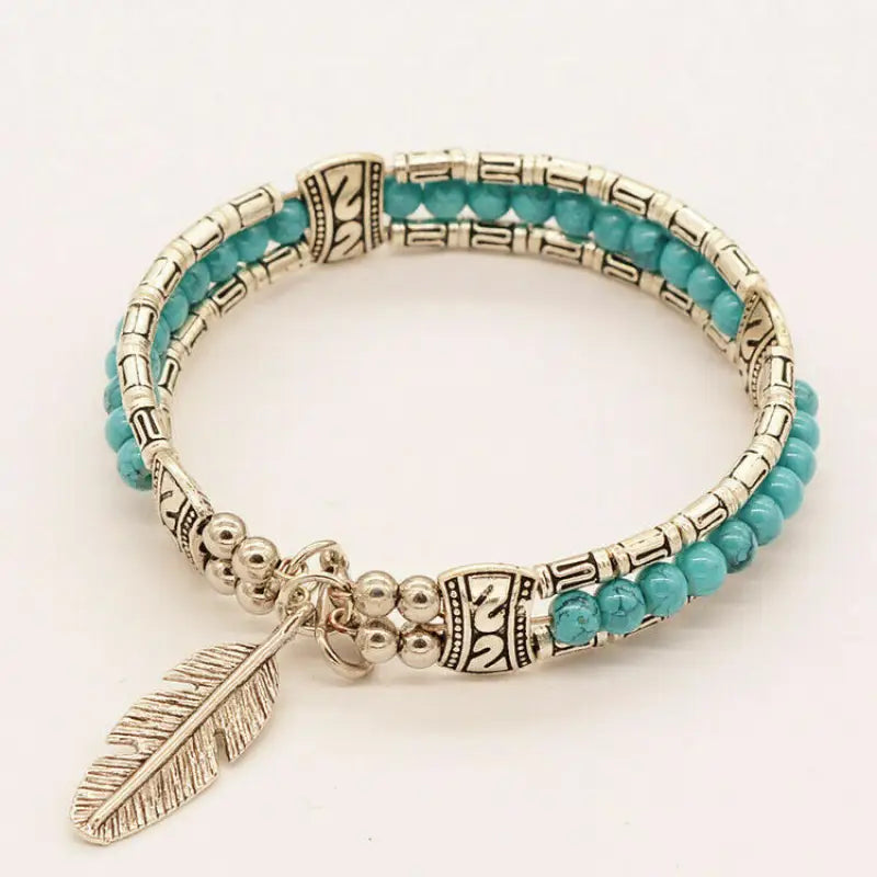 Turquoise beaded bracelet with a handcrafted feather charm in 925 silver
