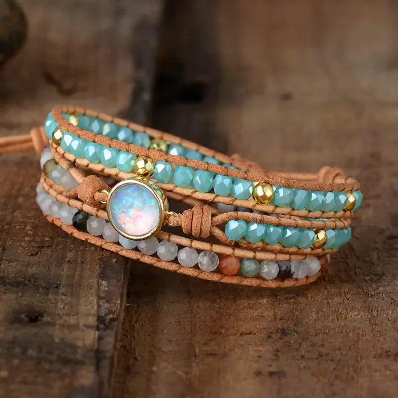 Artistic display of the opal wrap bracelet with blue and white beads secured by a golden clasp