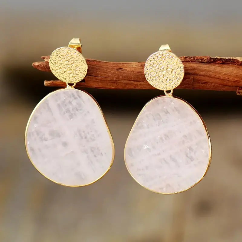 Rose Quartz Dangle Earrings on a display stand